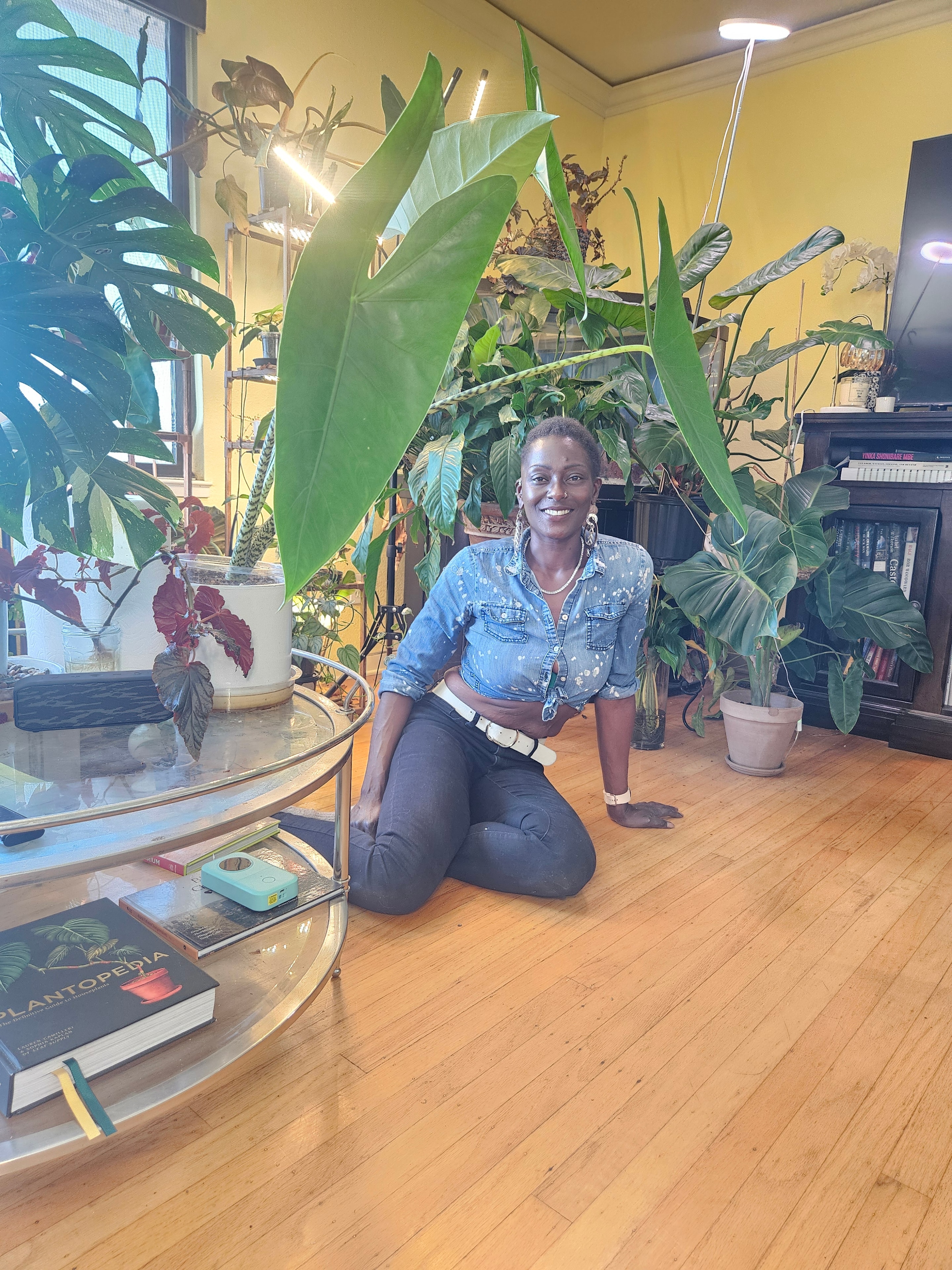 Courtney Jones, Founder & CEO of Tha Town Plantz, surrounded by her plant collection